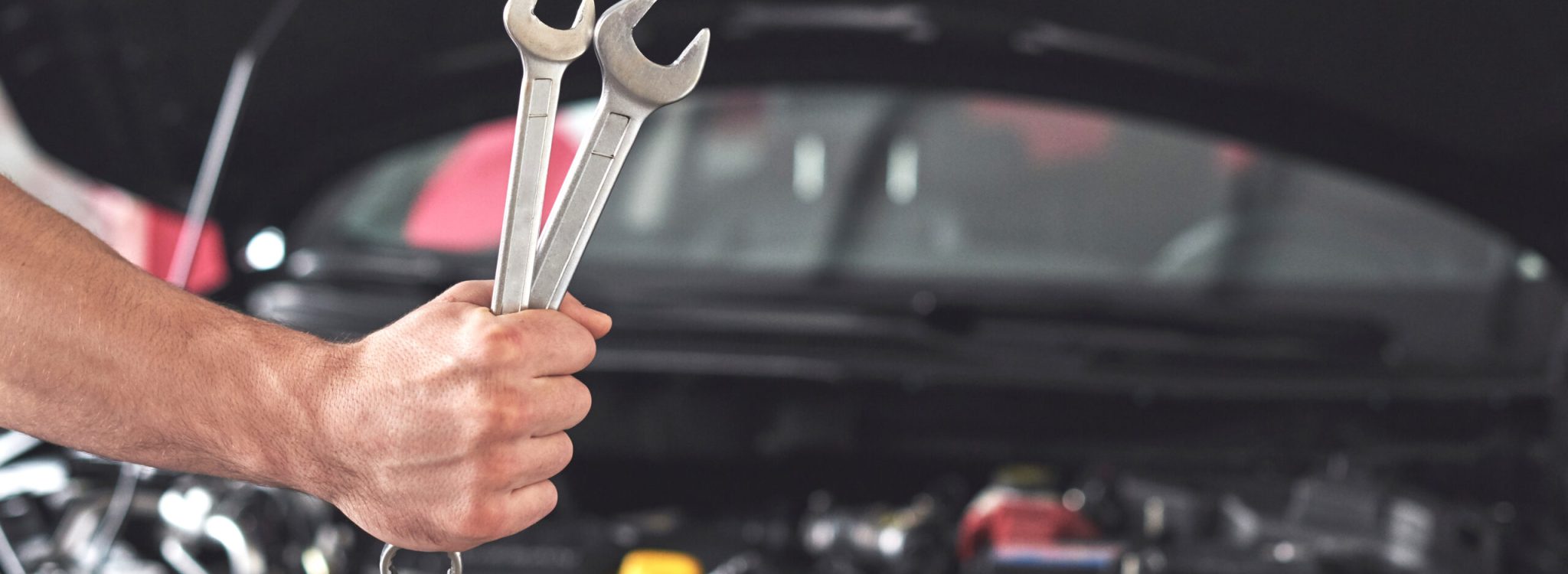 Mechanic holding pair of wrenches at the repair garage Mechanic holding pair of wrenches at the repair garage.